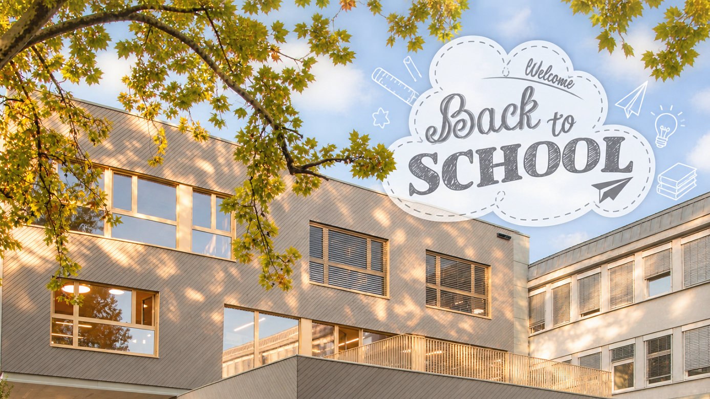 Schulgebäude mit Herbstlaub und Wolke „Back to School" im Himmel